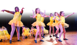 JDC students dancing, in yellow leotards and tulle skirts