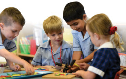 Four OSHC students playing at a desk